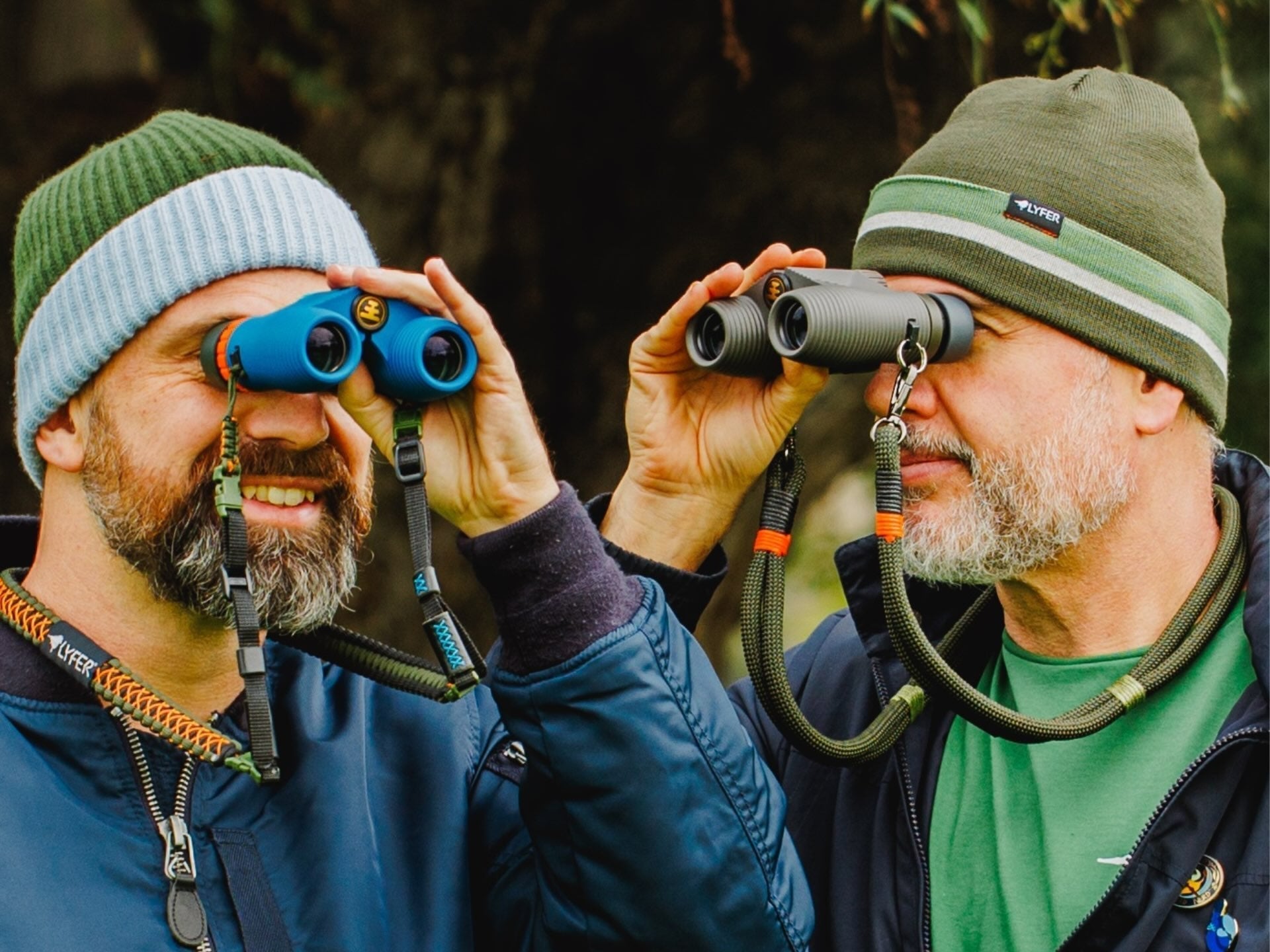 Two birders wearing LYFER beanies while looking through bincoluars