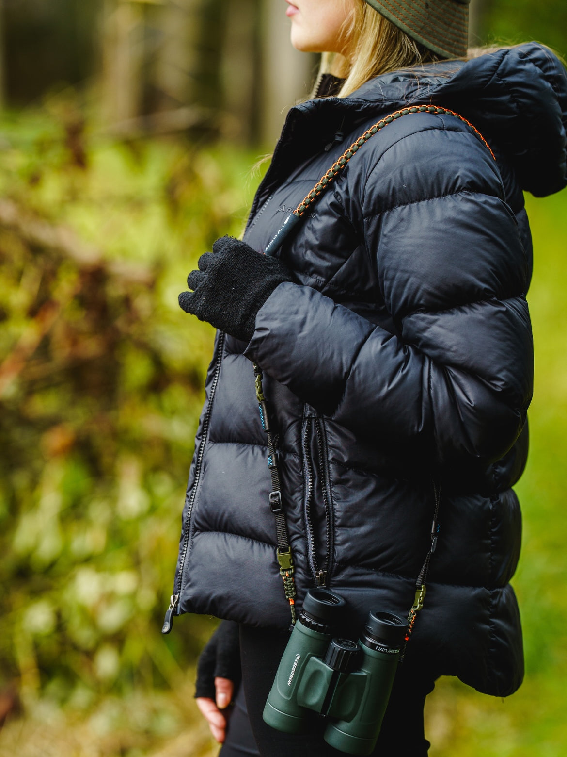 Adjustable Binocular and Camera Straps over the shoulder of a birder with binoculars.
