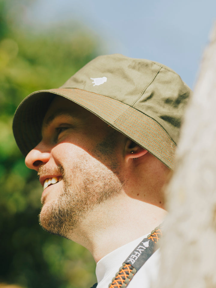 Model wearing Lyfer Green Bucket Hat, this is an ethically-made, recycled materials birdwatching hat , perfect gift for birders in Australia.