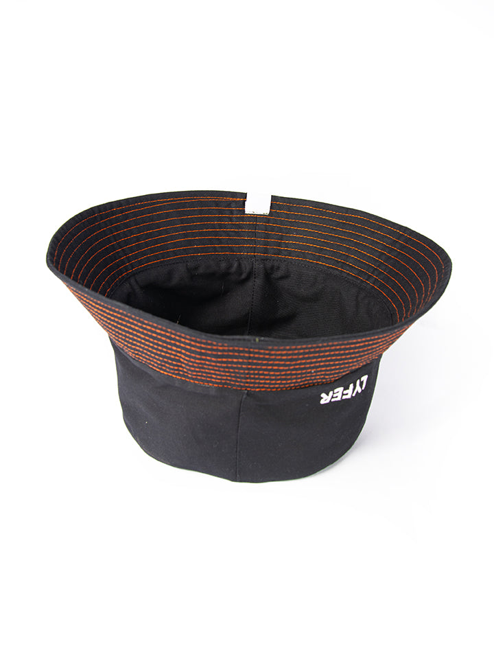 Upside down, and inside shot of Lyfer Black Bucket Hat with Lyfer Embroidery and original orange stitching, showing the position of the Its All About The Birds woven tag. Sustainably
and ethically made birdwatching hat is a great gift for birder in Australia.