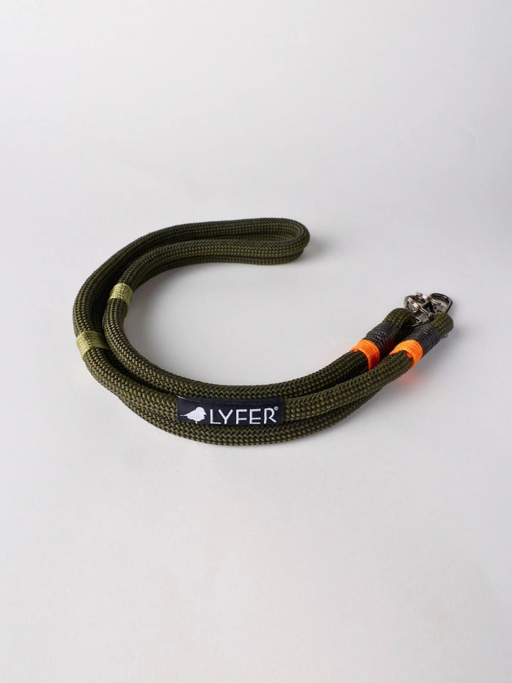 An olive green braided binocular strap with a black LYFER brand patch and orange accent rings, photographed on a light gray background.