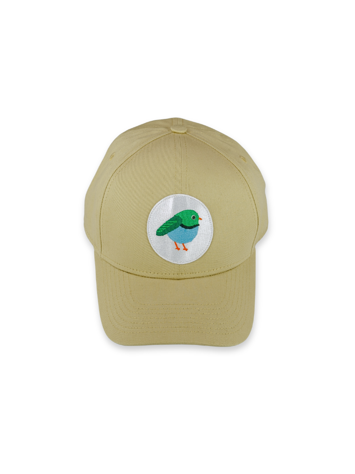 A sand coloured LYFER baseball cap featuring a circular white patch of a bird on the front with a colorful embroidered bird design.