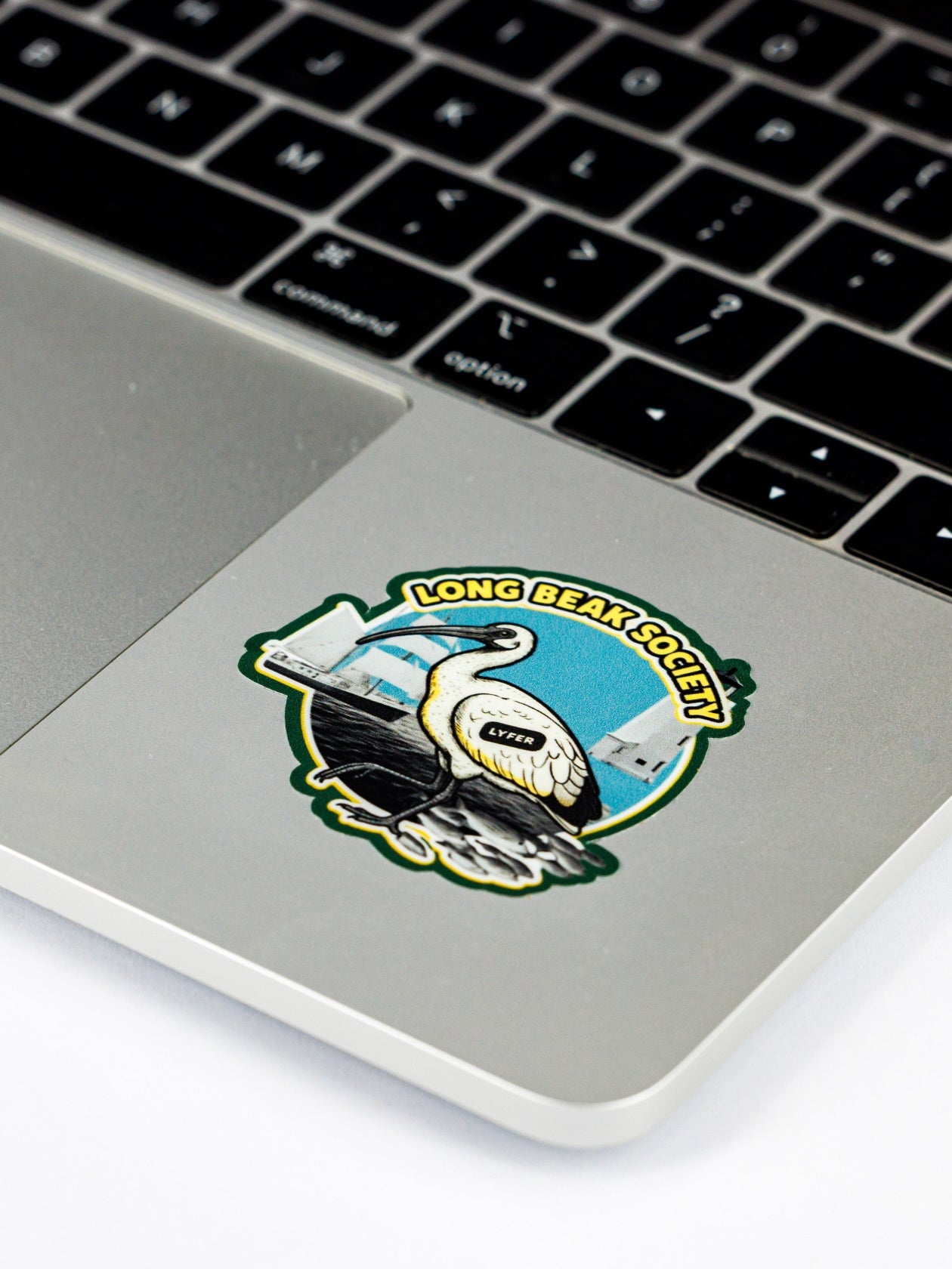 Laptop with a sticker of an Australian Ibis and 'Long Beach Society' text on the palm rest area.