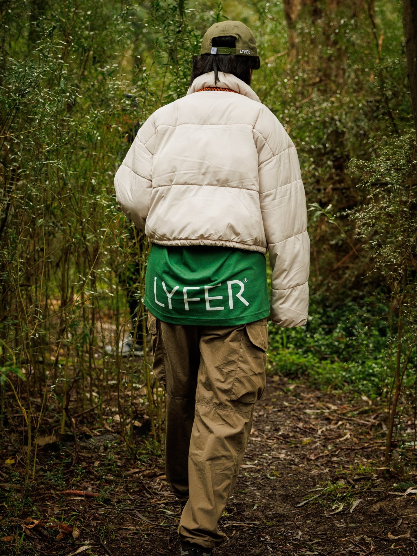 Model wearing the Lyfer BRAND tee out birding in nature showing the print hanging from below the jacket.