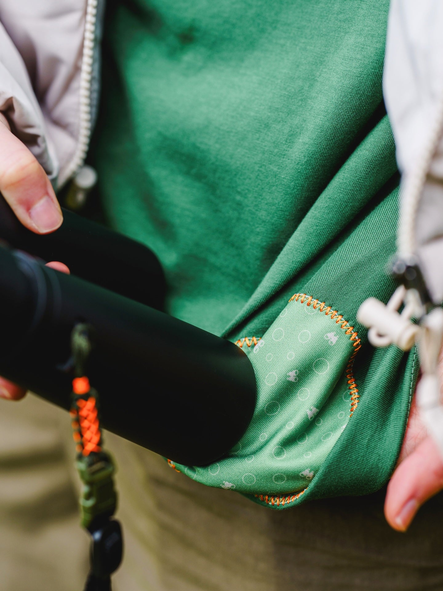 Close up of model wearing the Lyfer BRAND tee using the micro-fibre cloth to clean binoculars