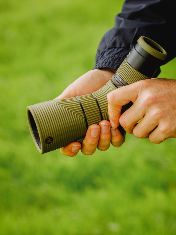 Person holding a green NOCS Scope Lite with a blurred green background