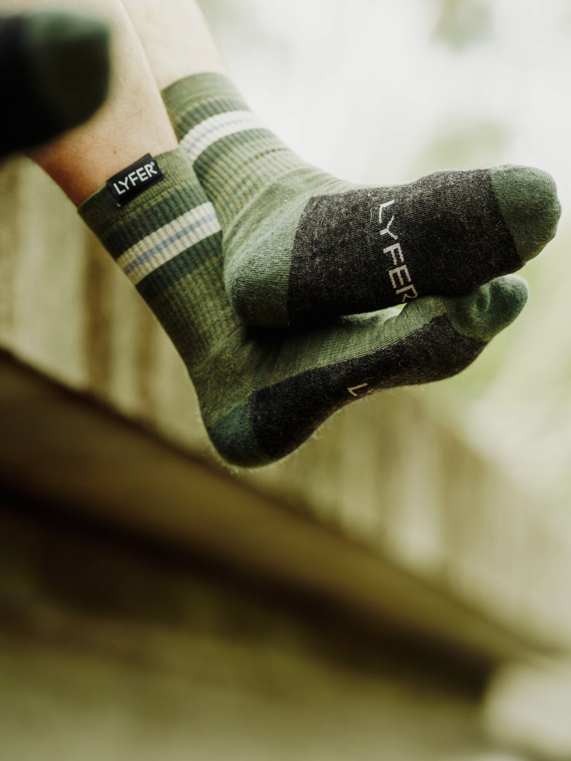 LYFER hiking socks with 'LYFER' branding on a blurred outdoor background