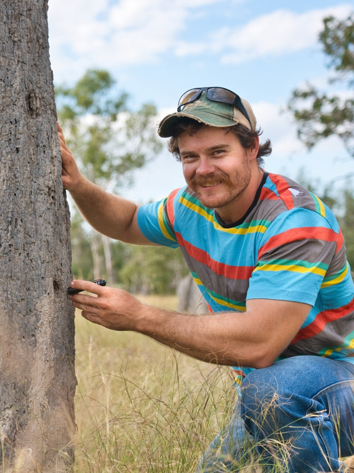 Worker at Artemis Station modelling the Golden shouldered Parrot endangered range t-shirt.