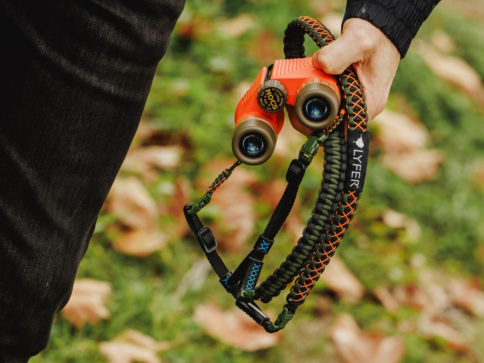Image of person holding NOCS binoculars wth Lyfer adjustable strap