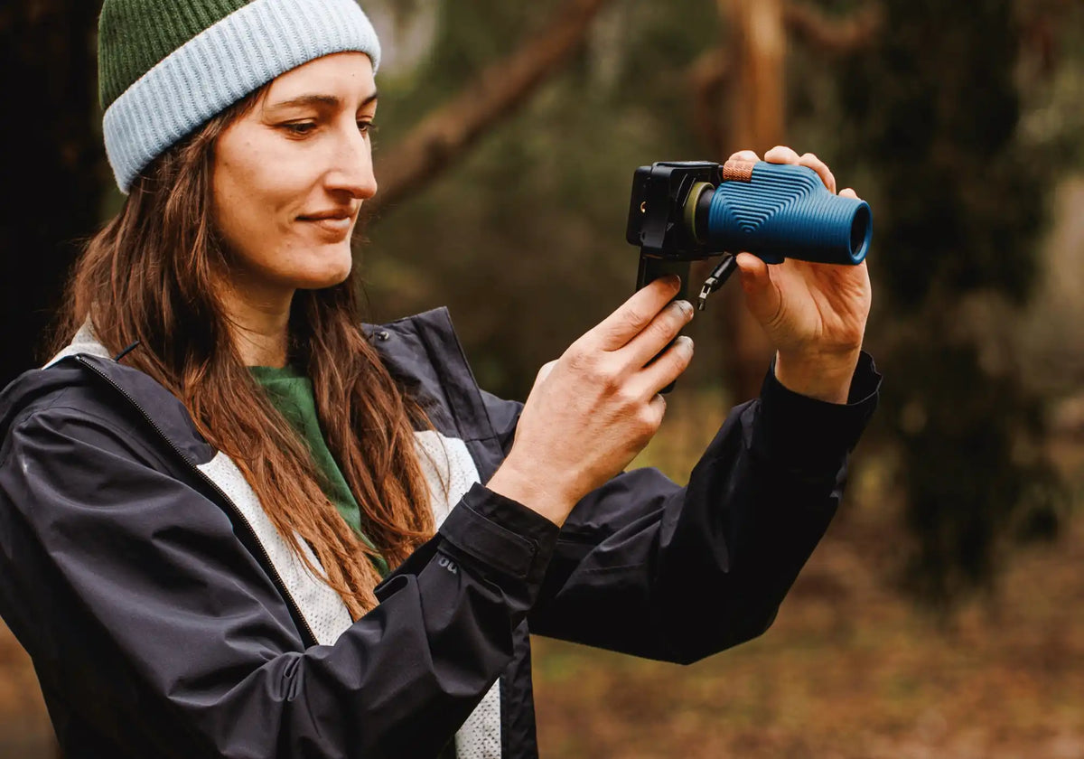 Image of model pouring coffee out of Lyfer Thermo Bottle into a Lyfer Field Mug out in nature.