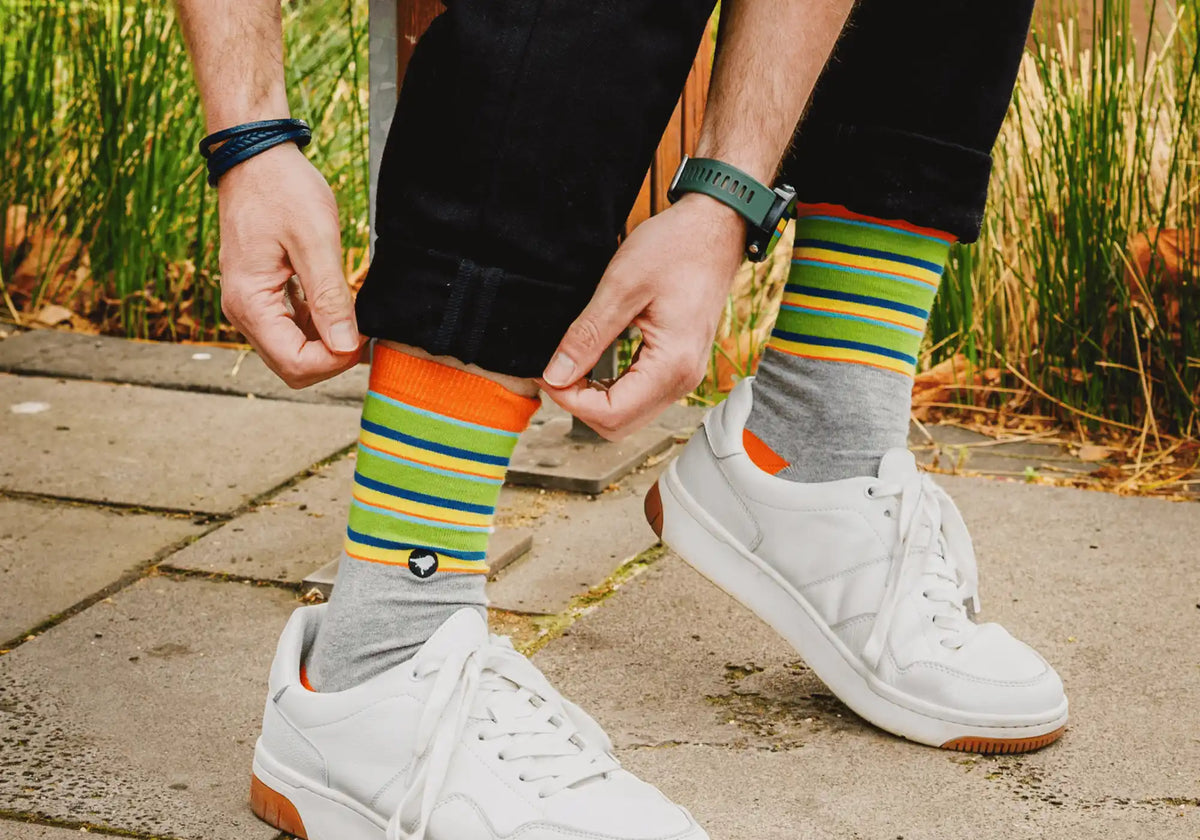 Lyfer outdoor socks worn by model sitting on fence
