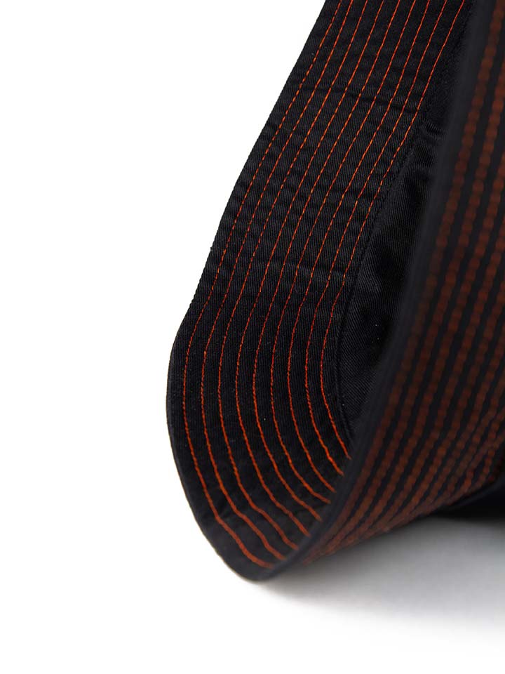 Close up shot of the orange thread stitching, and the quality of the 100% up-cycled cotton twill 