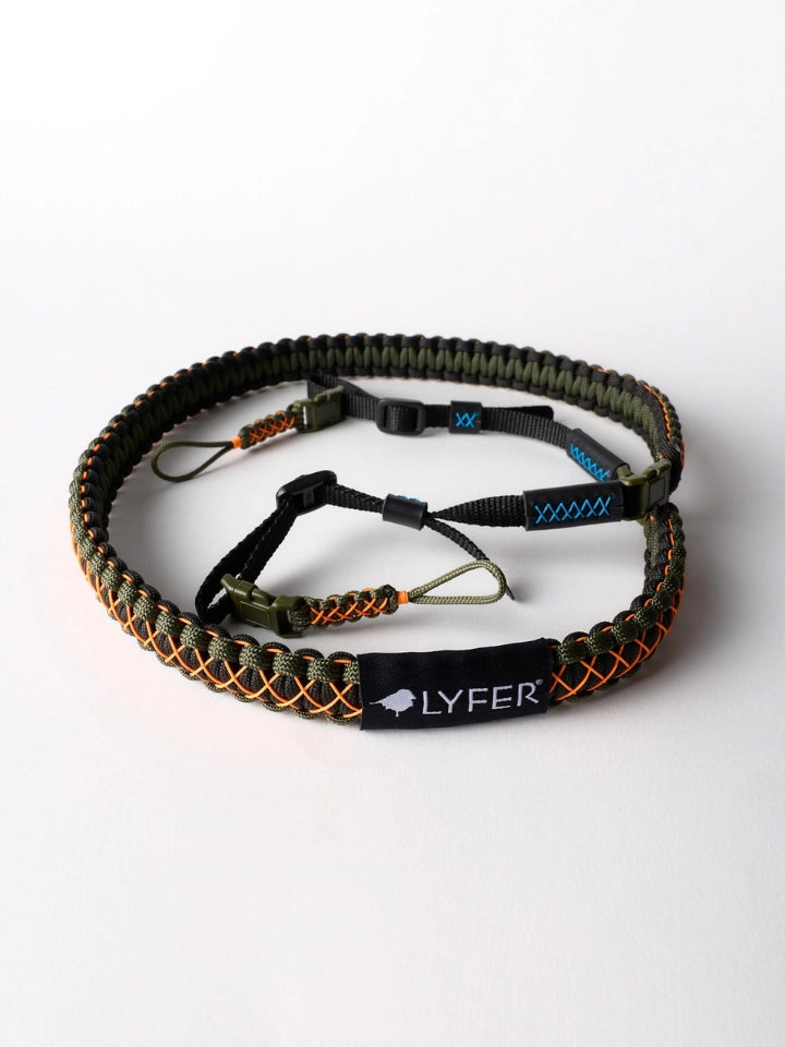 A paracord binocular straps with olive green, black, and orange braided details, featuring a black brand tag with the white text 'LYFER' and a small white fish logo, set against a plain white background.