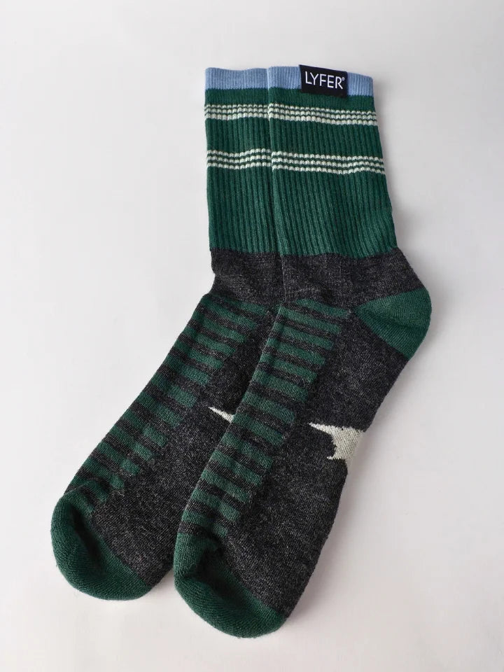 A pair of crew socks by LYFER, featuring a dark green and dark gray knit pattern with horizontal stripes and a small white graphic on the foot.