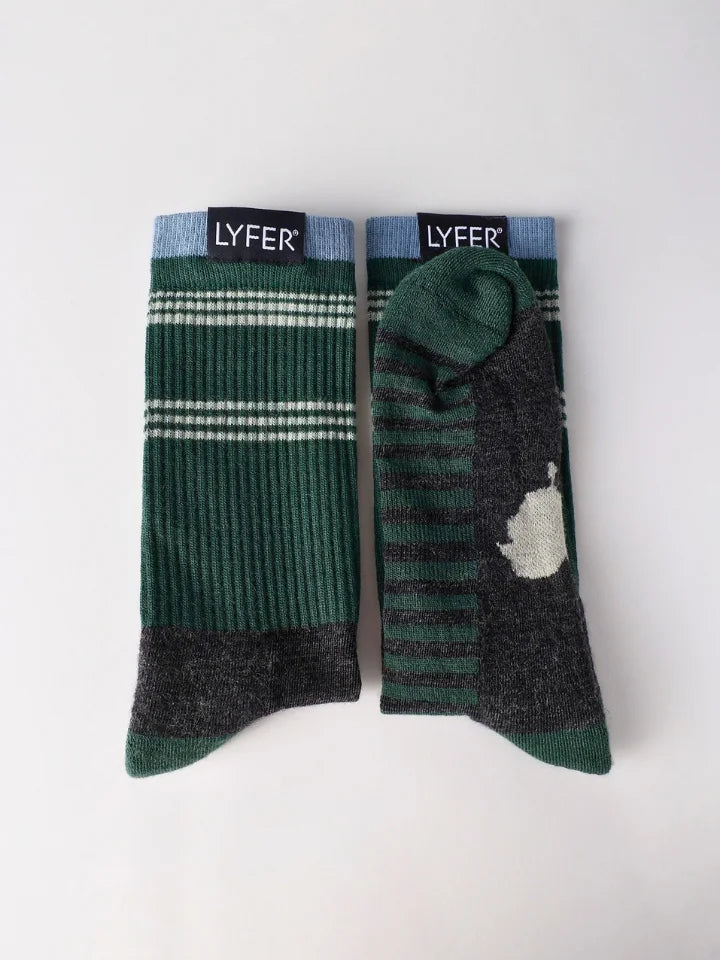 Two pairs of LYFER crew socks laid flat on a light gray background. One pair is dark green with thin white horizontal stripes and a dark gray ribbed cuff and toe.