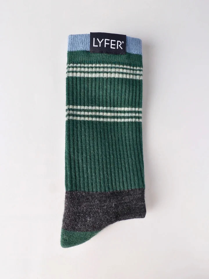A single ribbed crew sock from LYFER, featuring a dark green body with thin white horizontal stripes, a light blue cuff, and a dark gray heel and toe, displayed flat against a light off-white background.