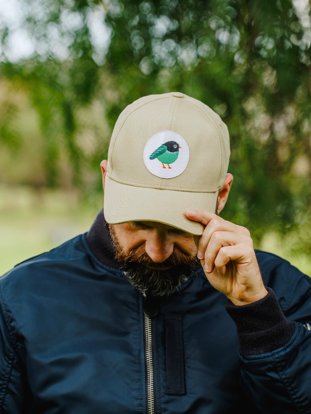 Model wearing an outdoor baseball cap with LYFER bird patch embroidery.