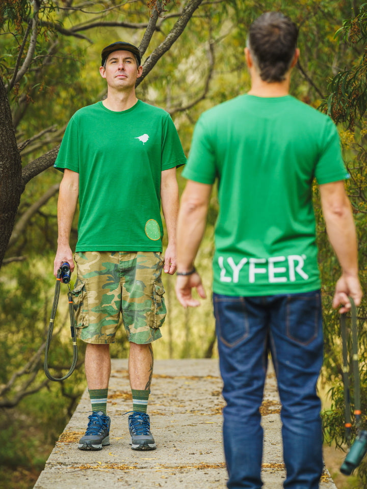 Two Models wearing Lyfer Brand Green T-shirts, back to back showing the design details and quality of the T-shirts. 