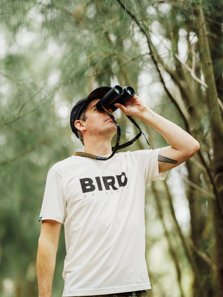 Birder outdoors wearing a  Bird Original Print of Lyfer T-shirt with Binoculars