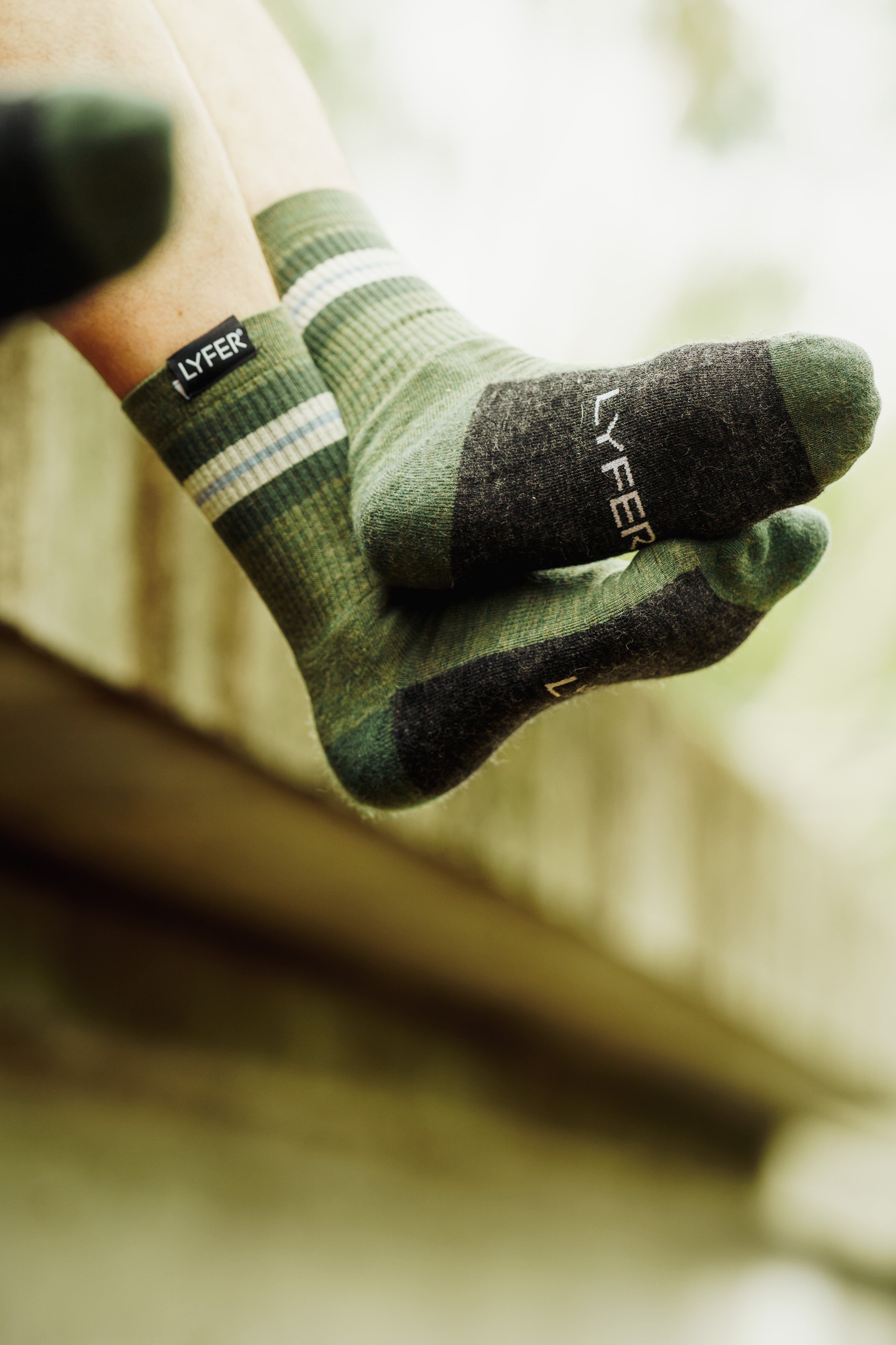 Close up of Lyfer branded Field Socks being worn in nature. 