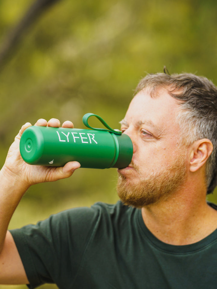 Model drinking out of the Lyfer Thermo Bottle