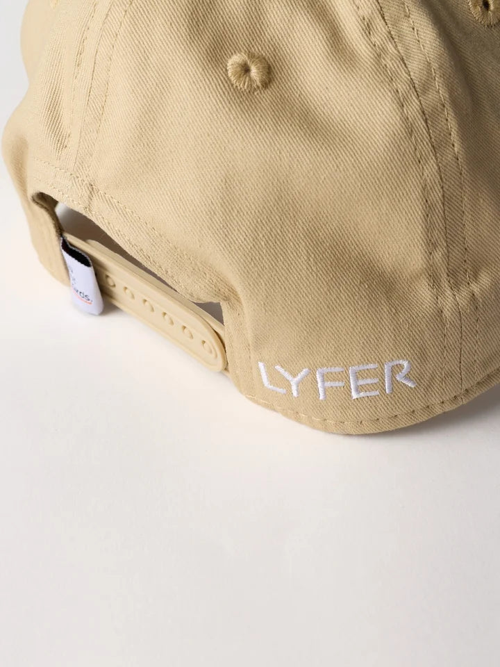 Close-up of the back of a beige baseball cap with an adjustable strap and white embroidered 'LYFER' text on the side.