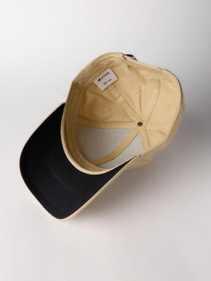 A structured baseball cap shown from an overhead angle, featuring a black visor and a beige crown with a light gray mesh back.